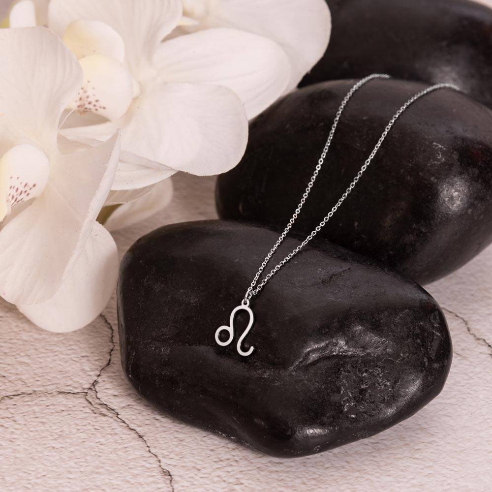 polished stainless steel Leo zodiac sign necklaces showcase on rock